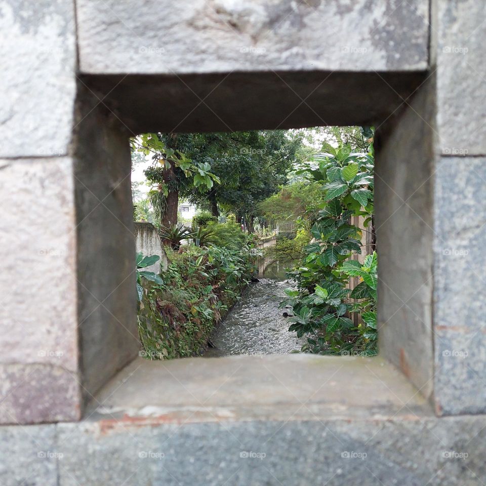 a hole in the wall of the bridge over the river