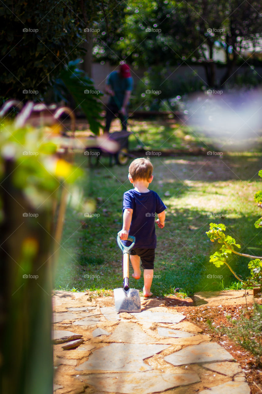 2019 memories - love this image of my boy on a mission to do gardening with dad. Boy walking with spade in the garden