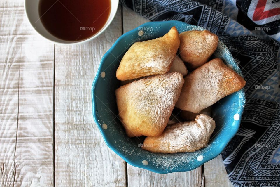 Traditional Kazakh baursaki pastry, yeast dough, fried in butter, sprinkled with powdered sugar and tea in a national saucer - kese