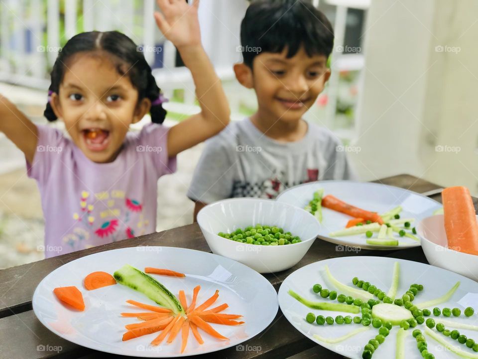 Kid’s having fun by doing creative activities with vegetables in summer time, both kids enjoying a lot by doing sun and trees with vegetables. Summertime is a special time for kids to enjoy like anything.