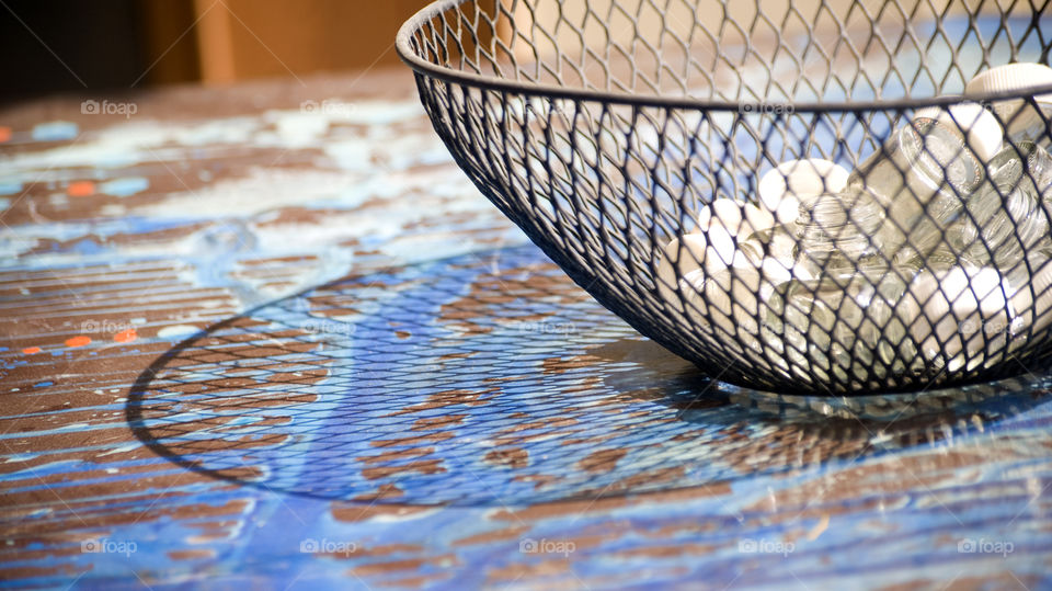 Net plastic container, its reflection and  glassy contents.