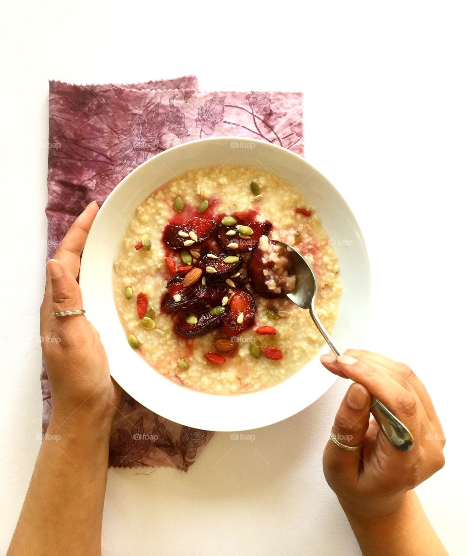 Oats breakfast with stewed plums and seeds
