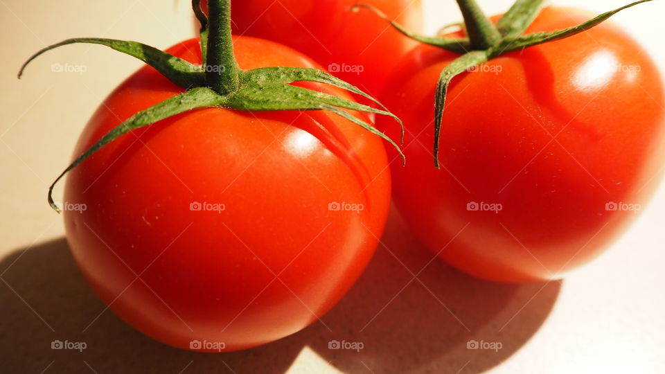 Closeup of red smooth shiny vine ripe tomatoes