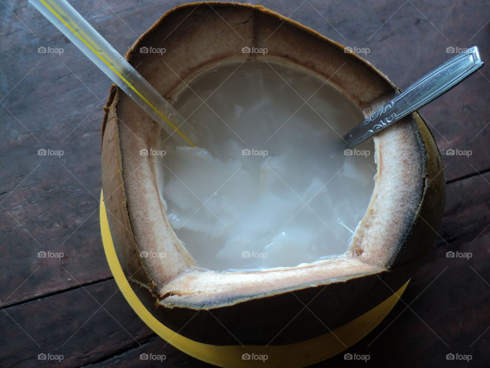 drink young coconut with a straw and spoon