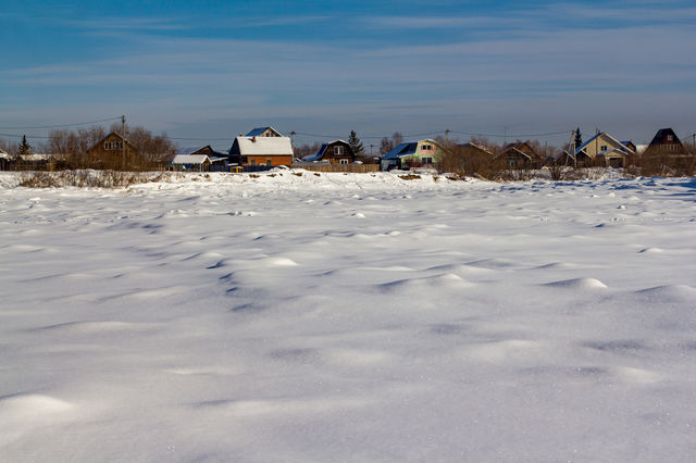 Houses against the backdrop of a frozen river.