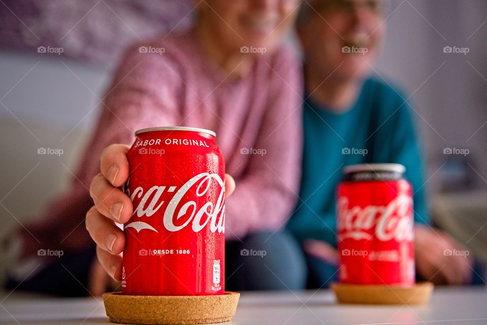 Couple watching television with two cokes