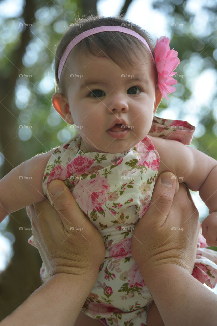 Person's hand carrying cute little girl