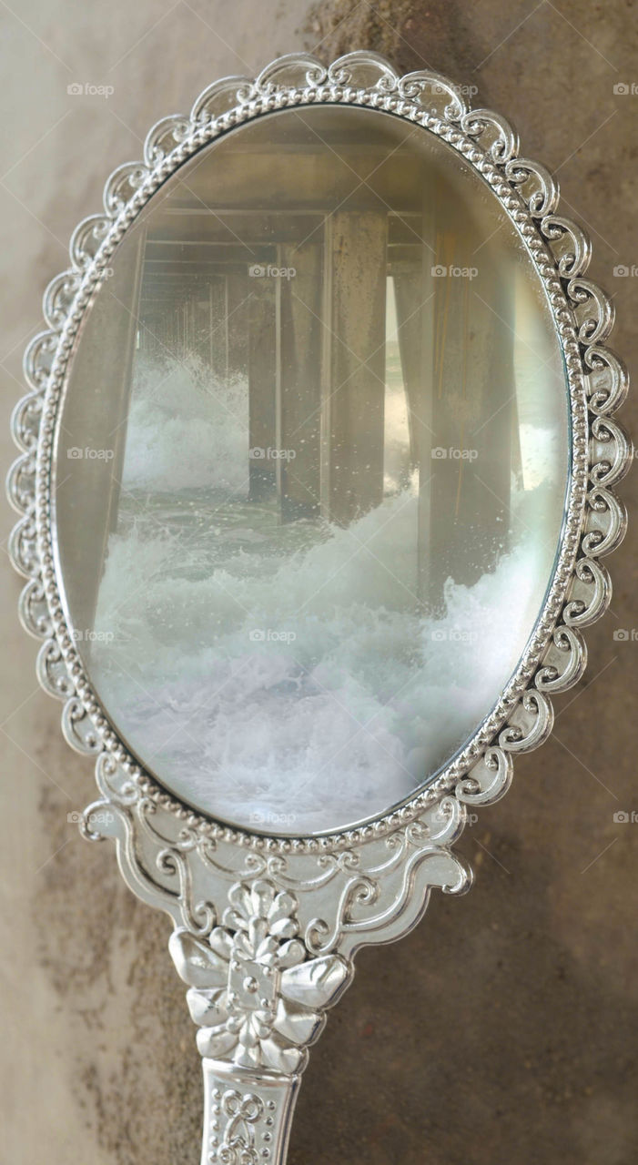 Antique Mirror Reflecting The Crashing Waves Under The Pier