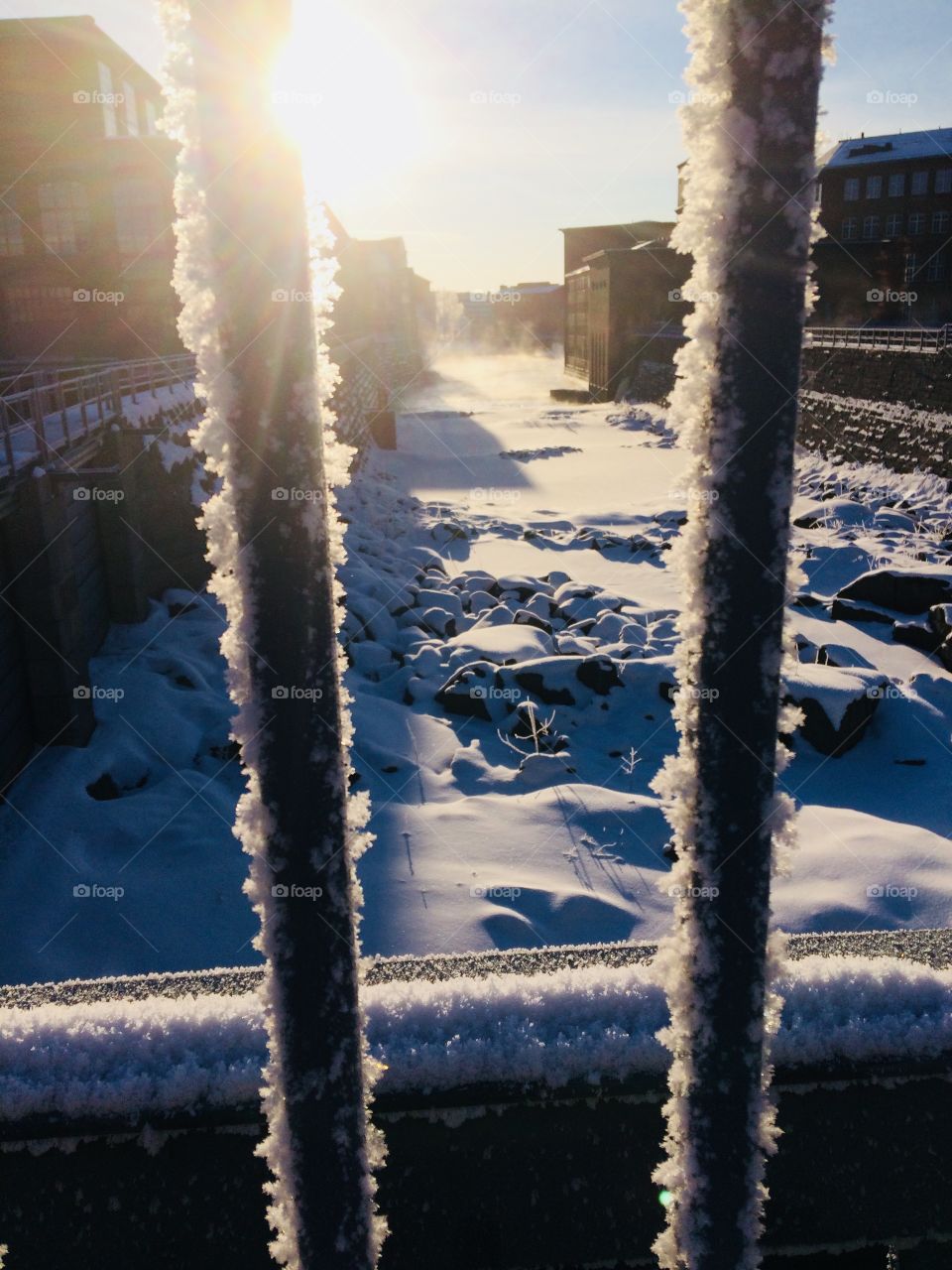 Sunrise in winter morning to a river through city 
