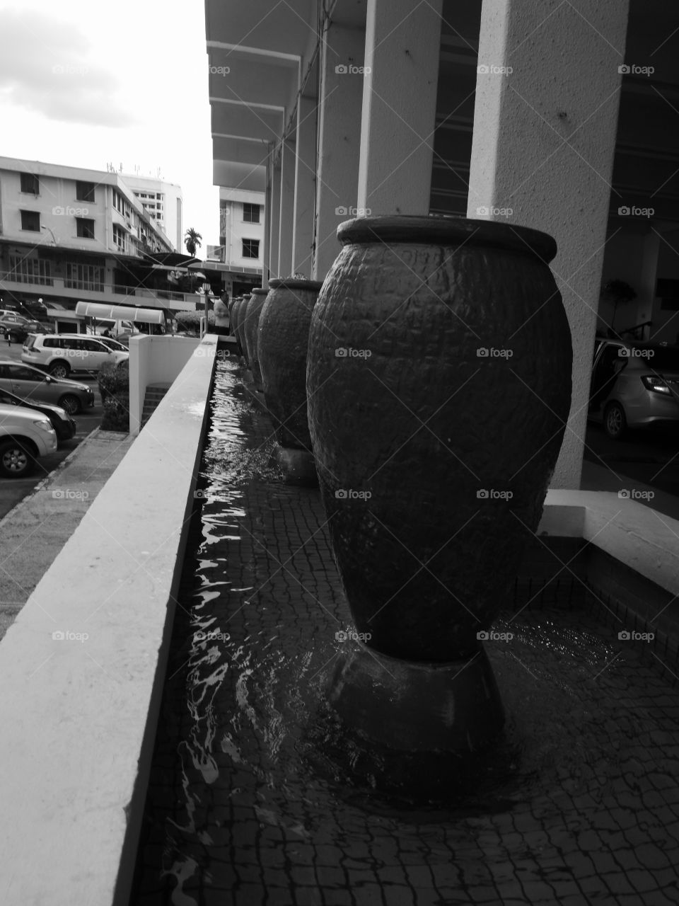 Row of water fountain pots in mono