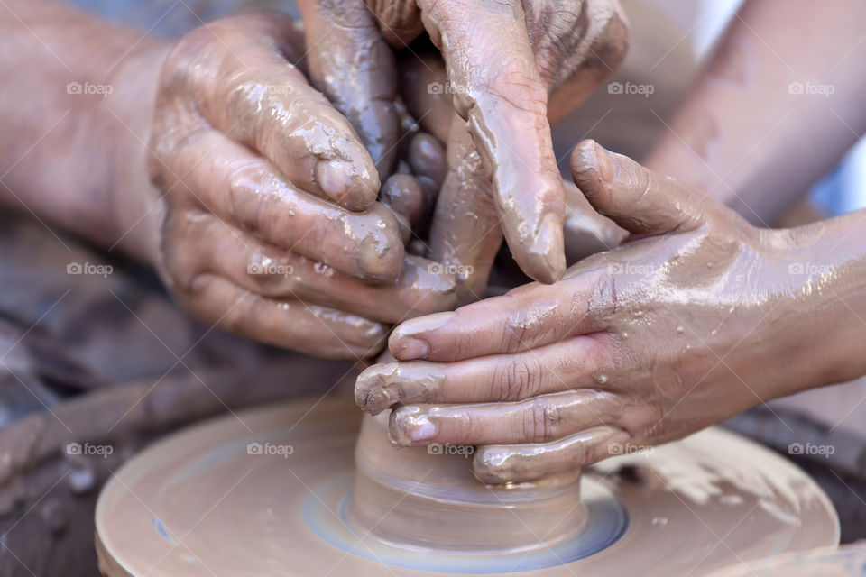 Close-up of two people making pottery
