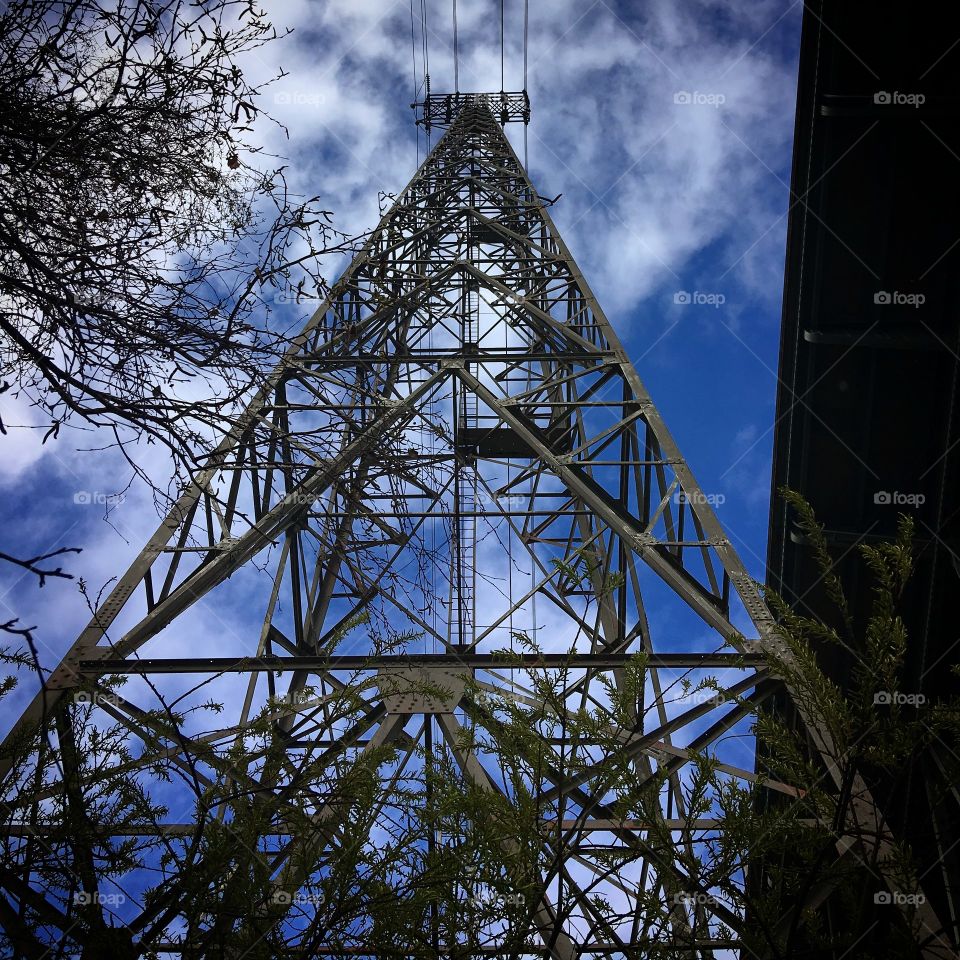 a majestic power pylon (powerline) stretching high into the deep blue sky