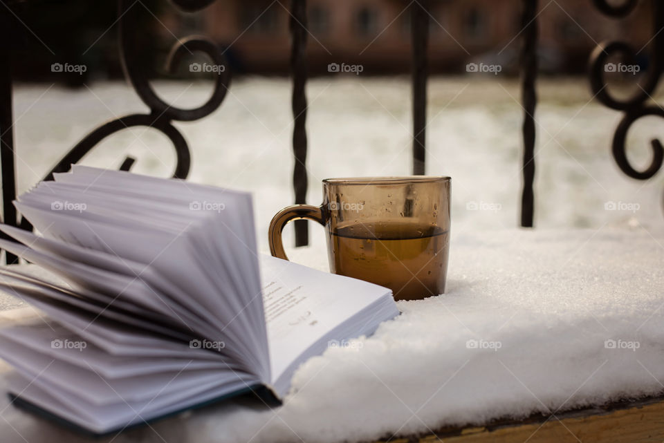 book and tea on snow