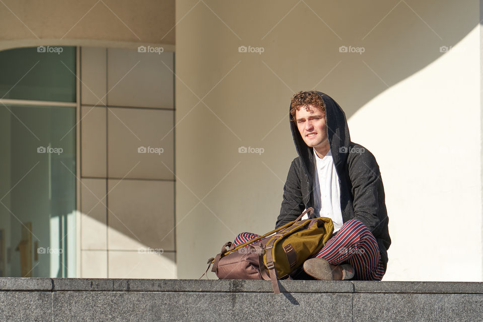 Young Man sitting in front of the MACBA