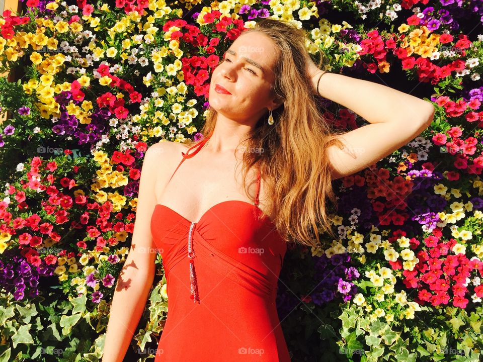 Woman posing in front of beautiful flowers