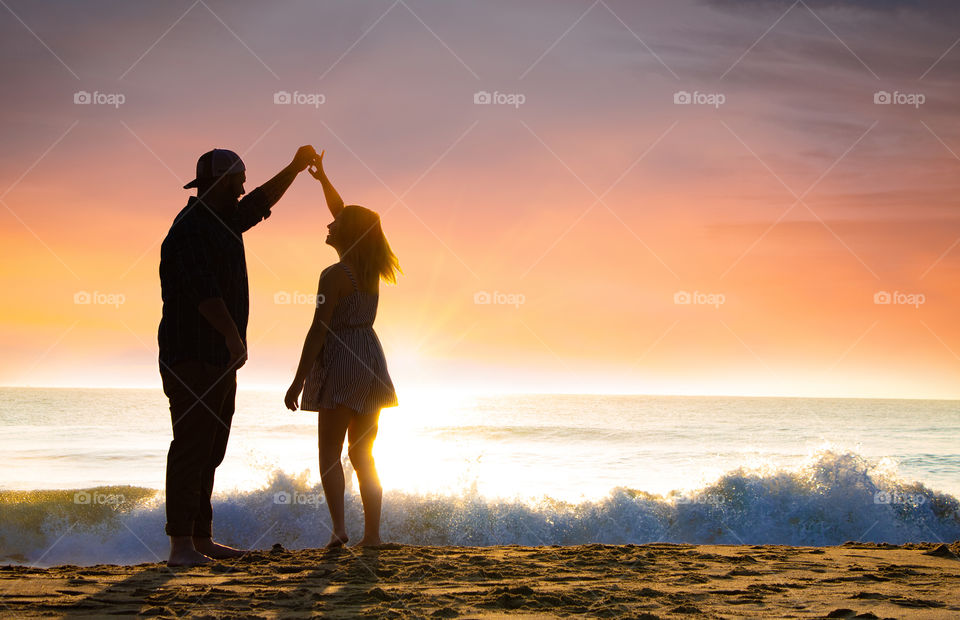 Young couple dances on the beach