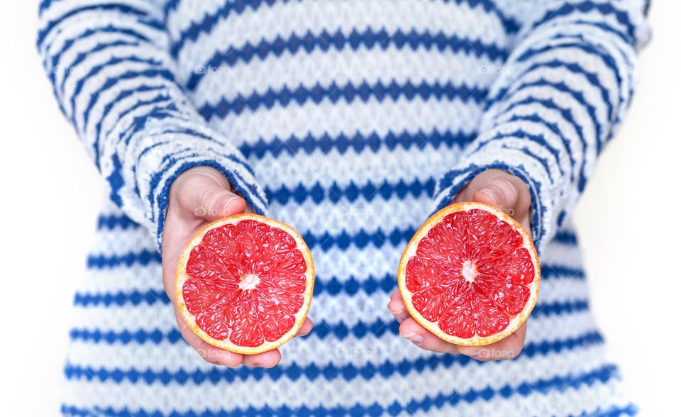 Grapefruit cut in half in hands