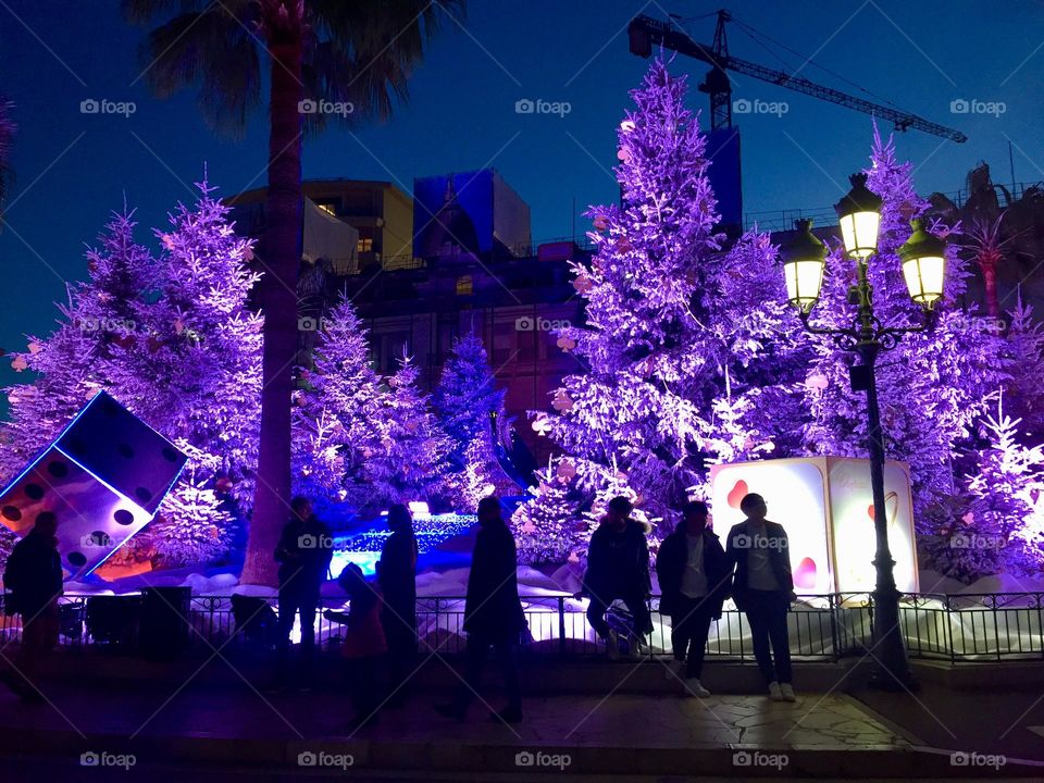 Christmas purple city lights in Monaco Monte Carlo and unrecognizable pedestrian people silhouettes 