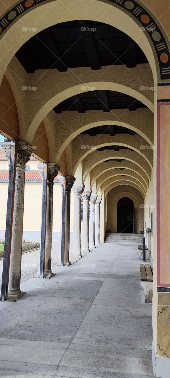 A long walkway with beautiful Doric columns and arches leads to another section of the “Nordfriedhof”, the “North Cemetery” in Munich, Bavaria. Several of my departed relatives are resting there. 2023. Hypnotic Productions