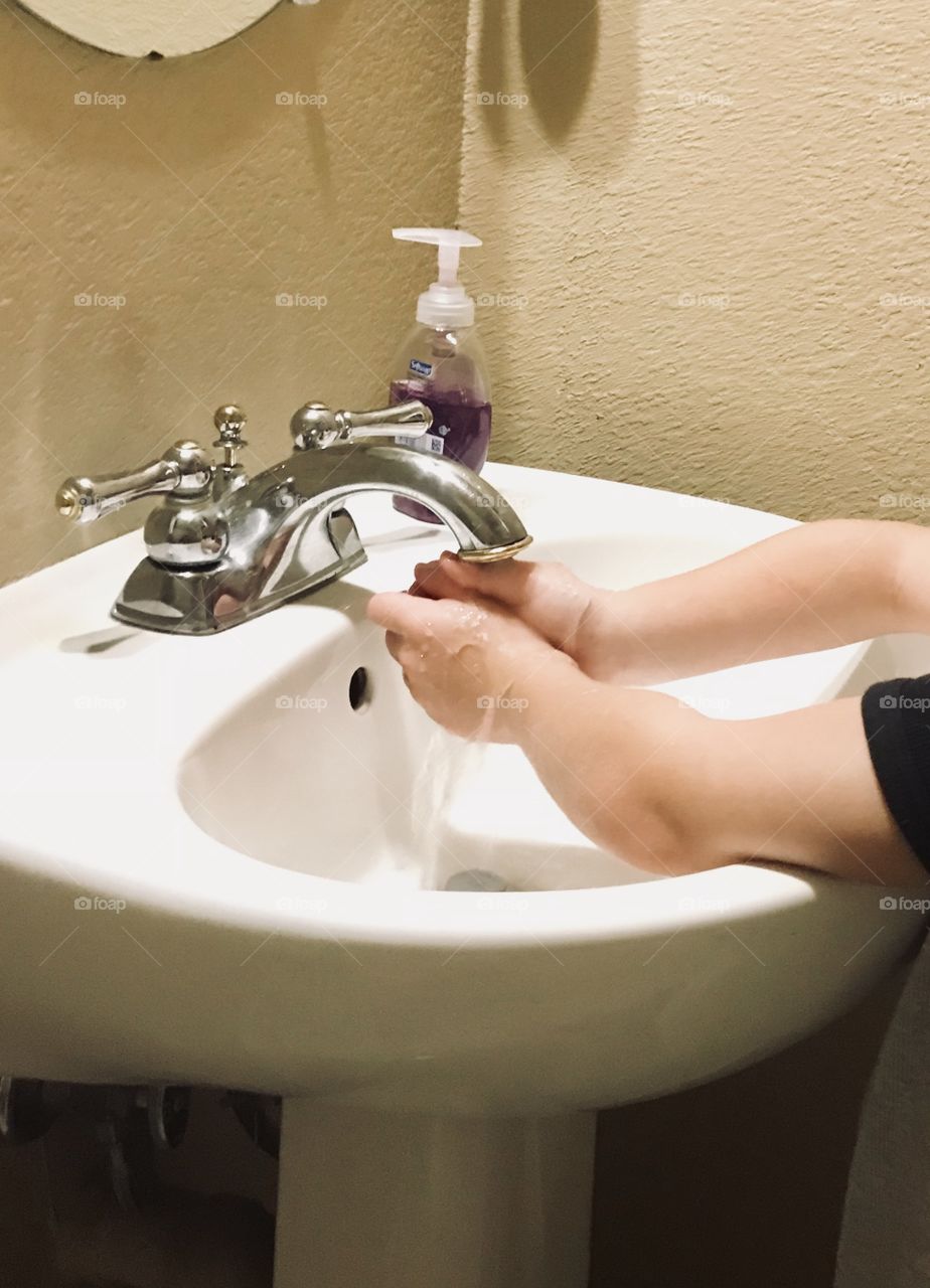 Child Washing hands in the sink at home - personal hygiene keeping hands clean 