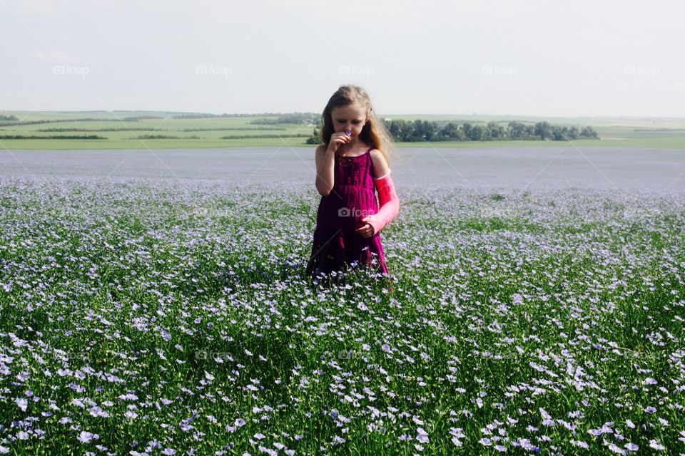 Girl in sea of purple flax.