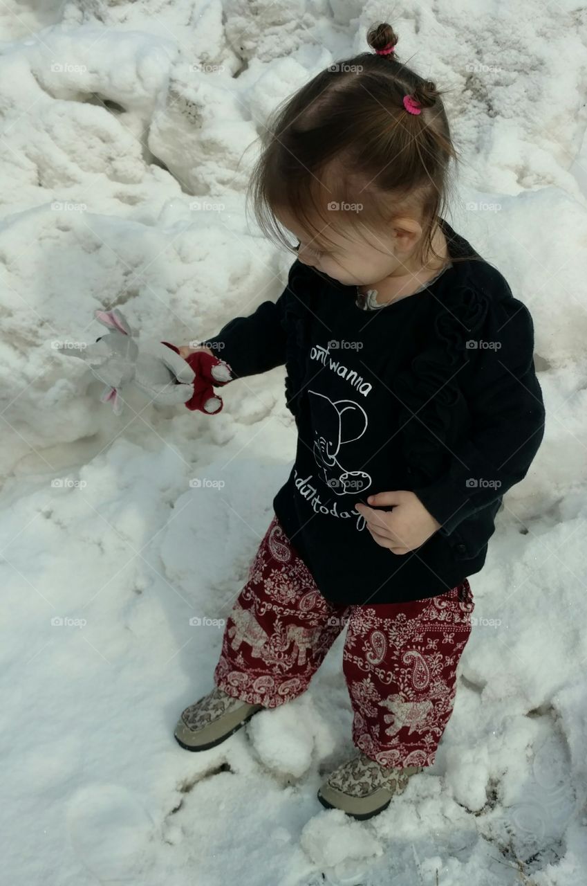 Girl in winter playing with stuffed toy