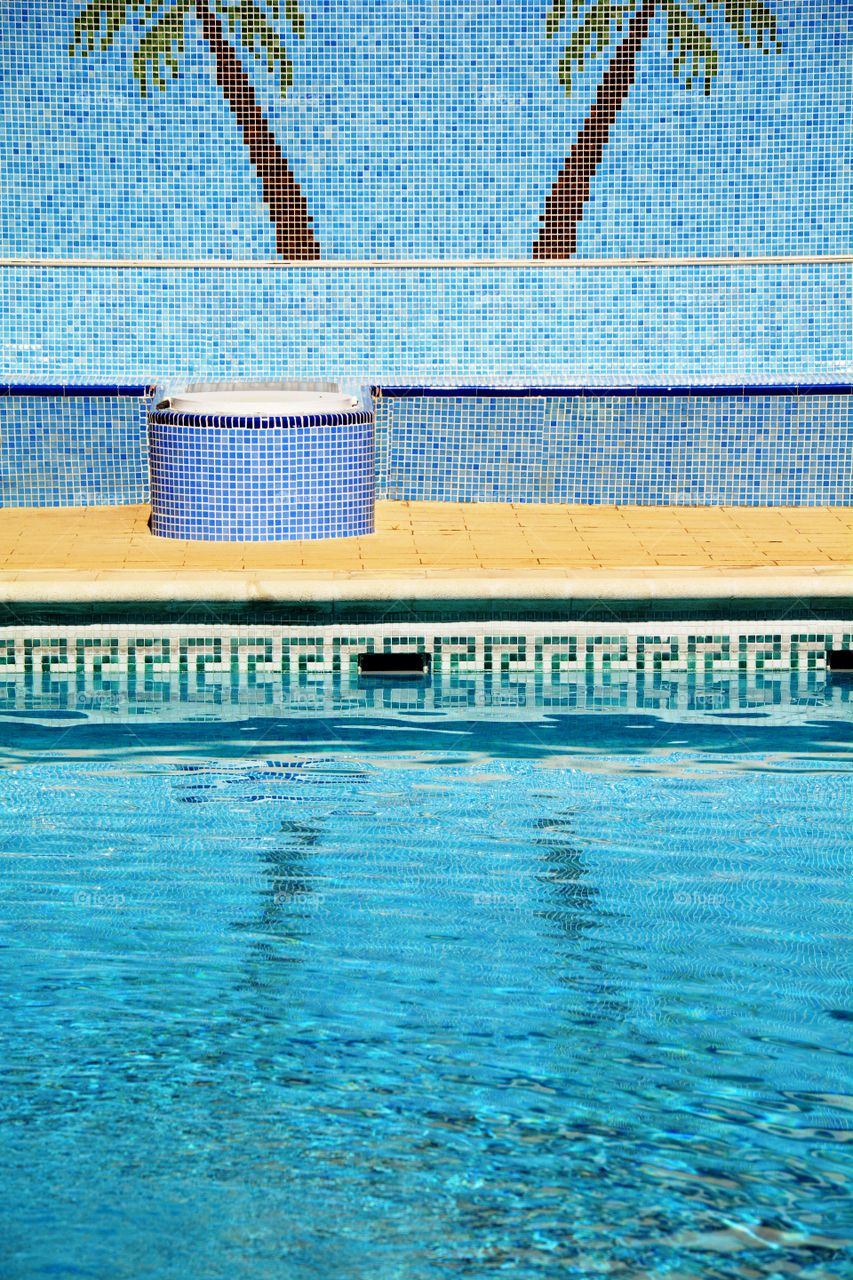 palm trees in the tiles decorating the swimming pool