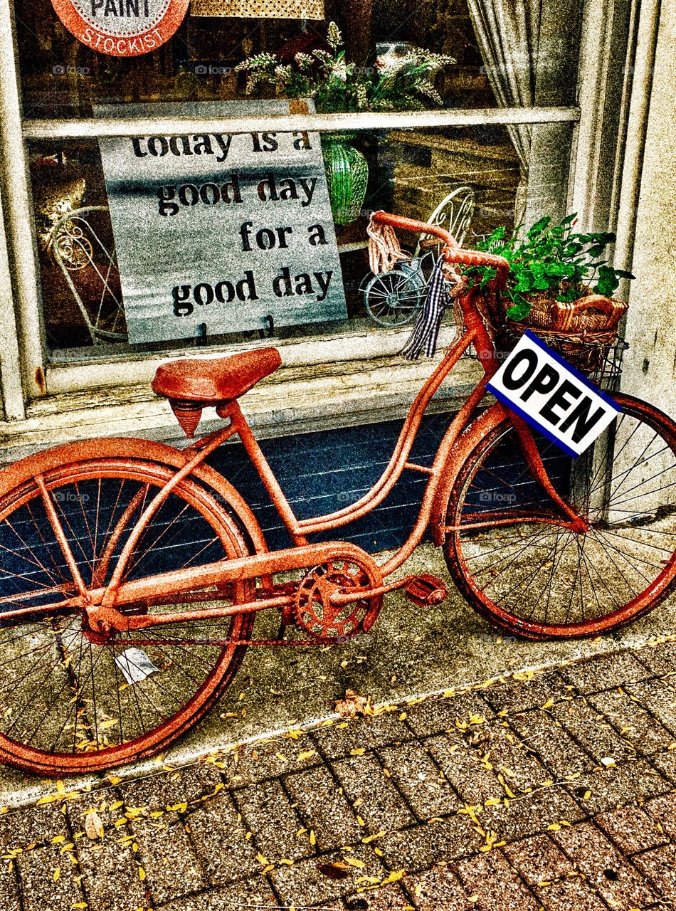 Rust Red Bicycle in front of store window with a sign that say... Today is a good day for a good day. 