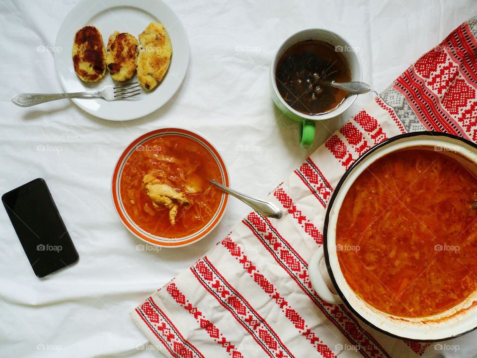 Ukrainian borscht, pies with meat and a cup of tea on the table