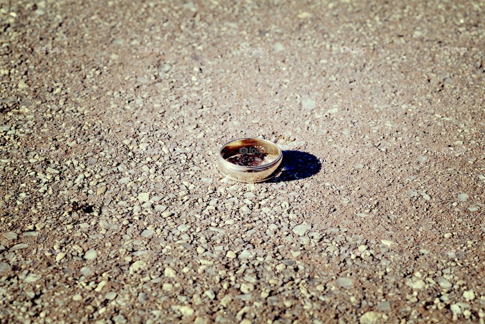A wedding band sits atop a stone ledge.