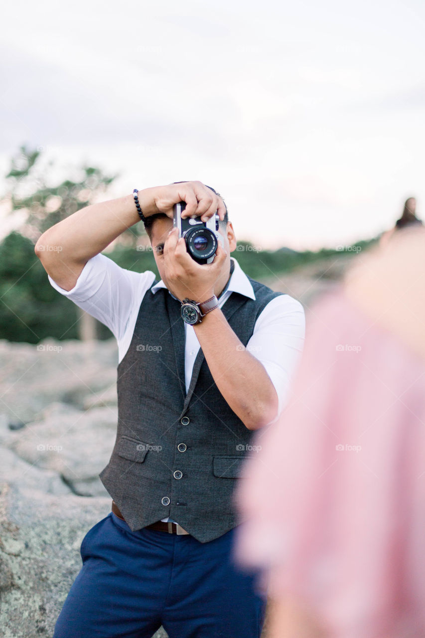 Man taking photos from film camera 