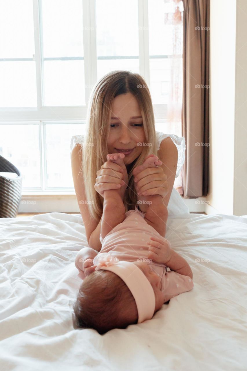 Young mother with her newborn daughter at home