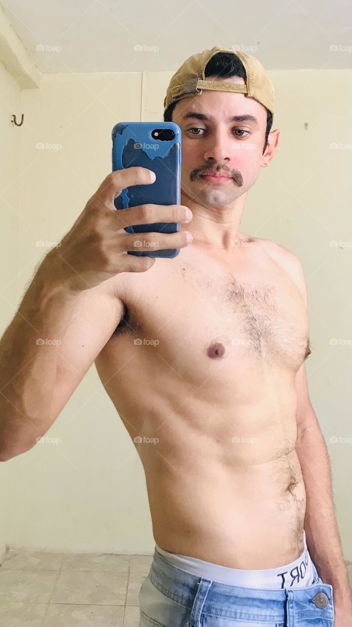 Man with mustache taking photo in mirror