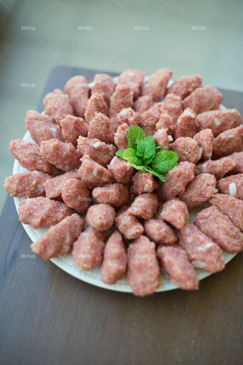 Kibbeh nayeh in white plate with mint. Syrian levantine mezze.