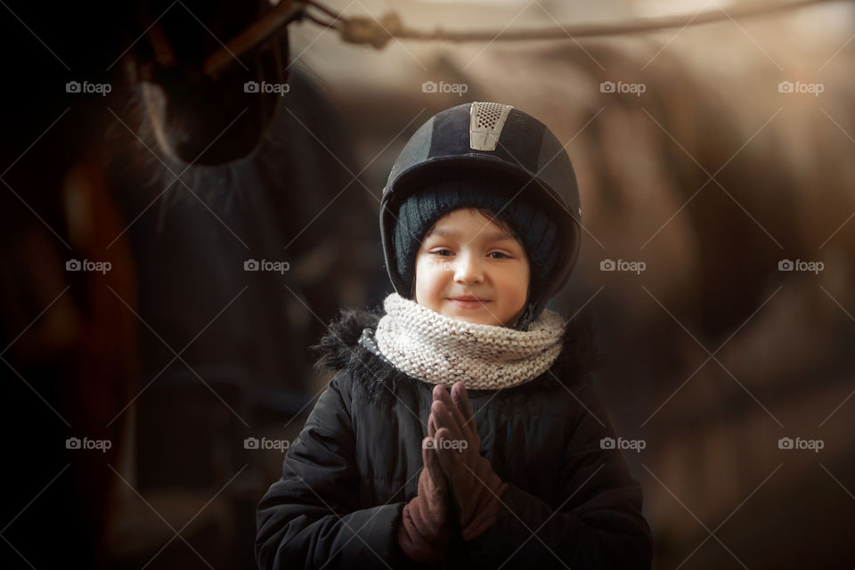 Girl in horse riding wear in a stable