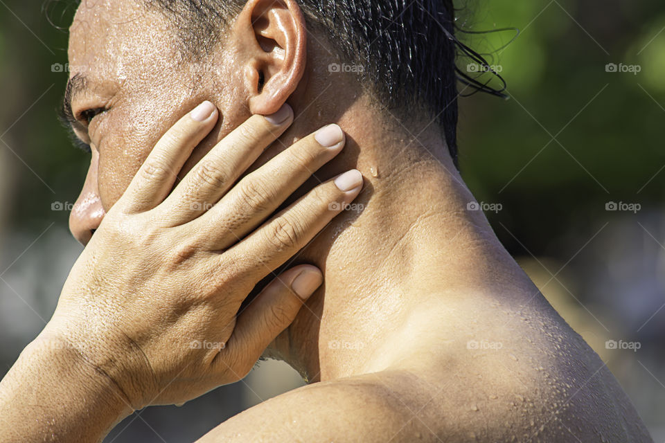 The hand grips the neck that inflammation from a sports injury.