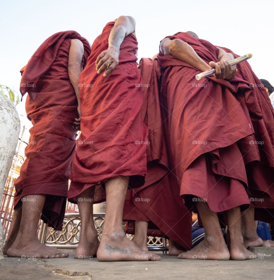 Bakan/Myanmar-April 16 2019:Many monks stand aroud puddle to see beautiful reflection shadow of Shwezigon pagoda 