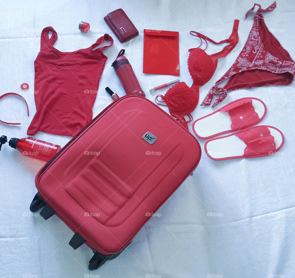 red suitcase and red clothes flatlay