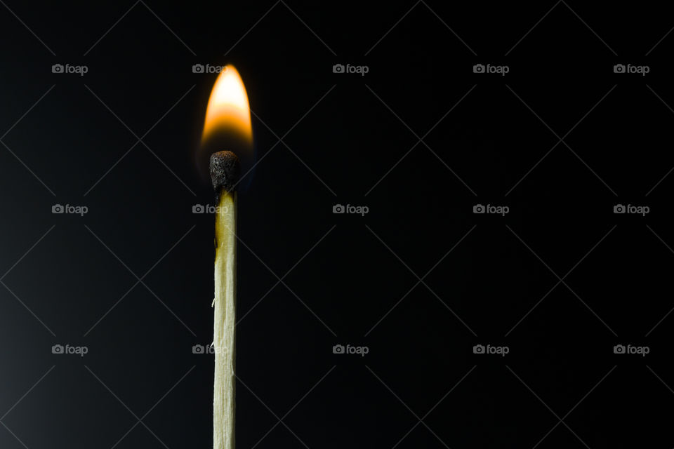 Burning match on a black background