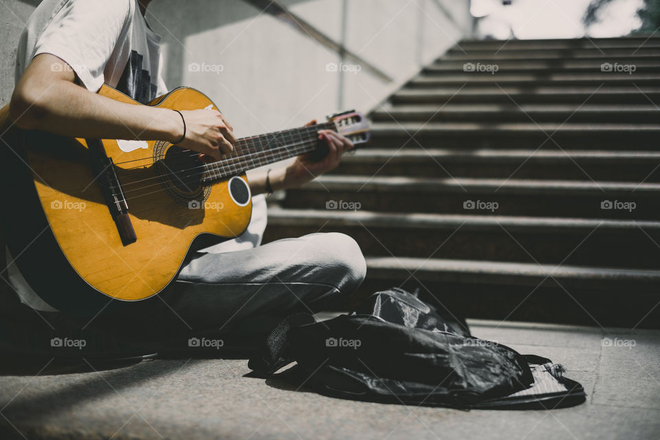 Street musician playing with guitar for reward