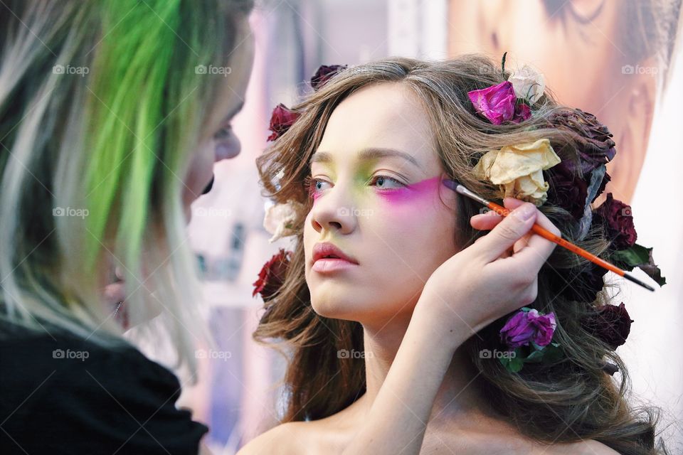 Makeup artist doing art makeup on a model