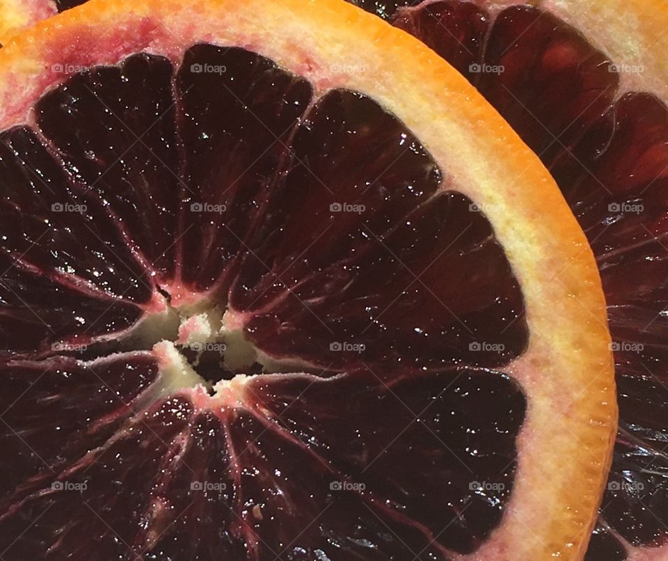 Slice-zoomed in   A cropped look at a slice of a juicy blood orange.  