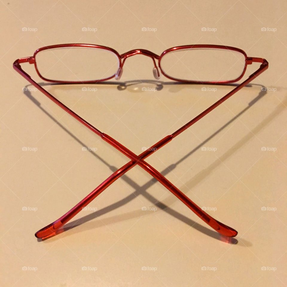 Red thin wire reading eyeglasses. The eyeglasses have clear lenses that fold thin.