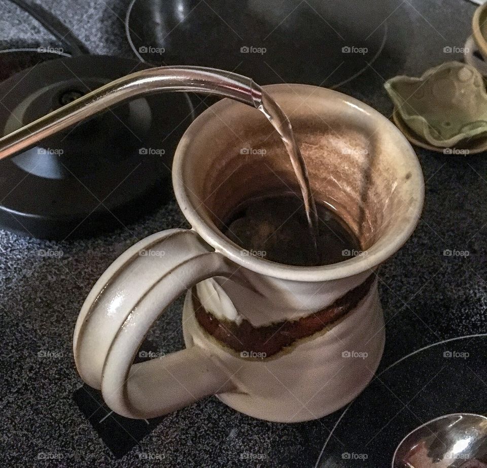 Cuppa tea.  Pouring hot water from an electric kettle into a mug.  Morning ritual 