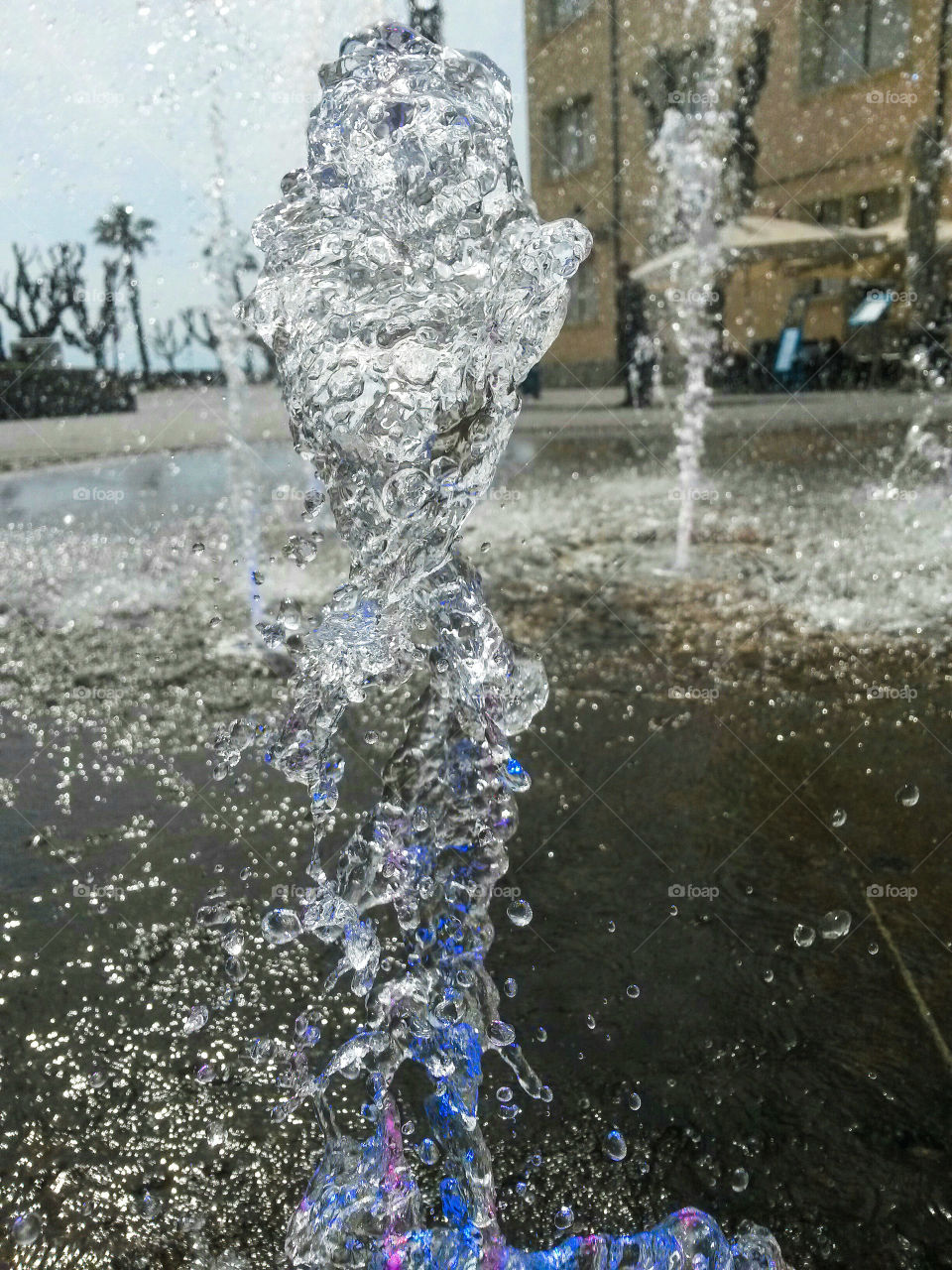 water in motion: Close up of water splash from a fountain with colored light