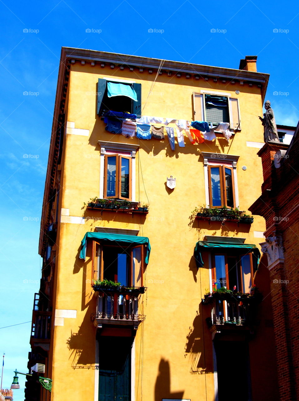 laundry drying on a yellow Italian house