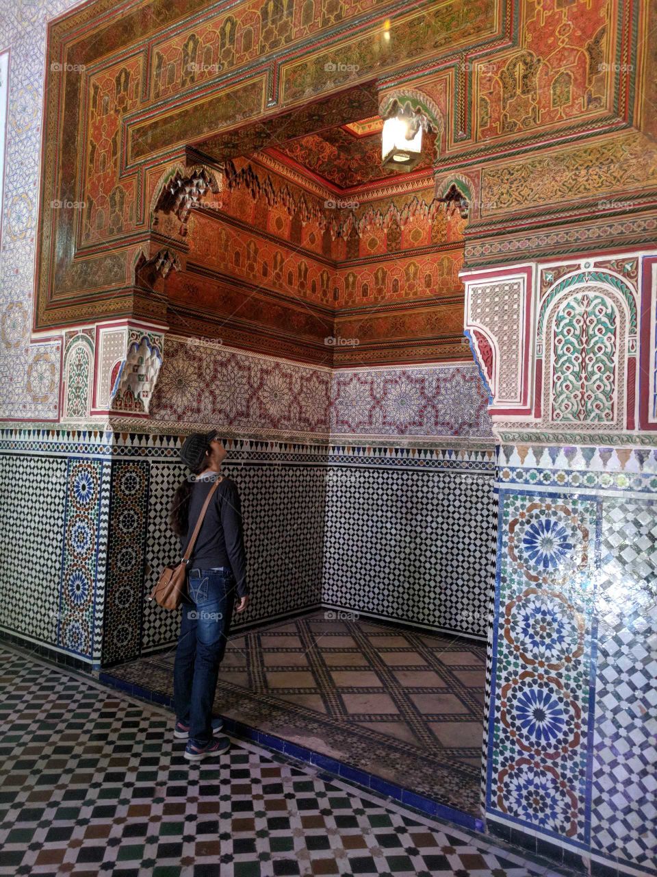 Single Female (Adult Woman) Gazing At and Inspecting the Colorful Ceramic Tile Mosaic Walls and Room in the Bahia Palace in Marrakech in Morocco
