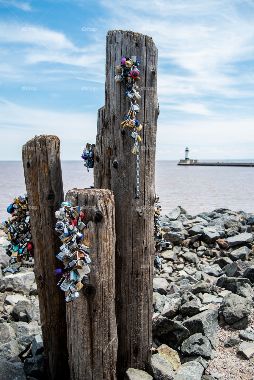 Many locks hanging on columns at the beach