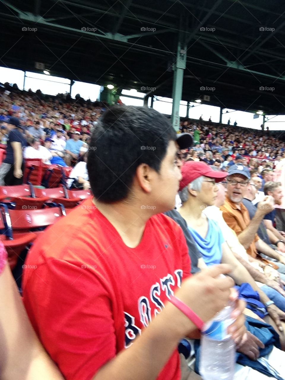 Man watching baseball game with a crowd in a large stadium