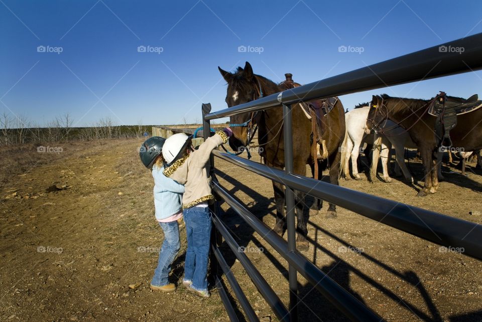 2 children petting a horse
